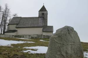 Die alte Kirche von Falera mit einem der Menhire